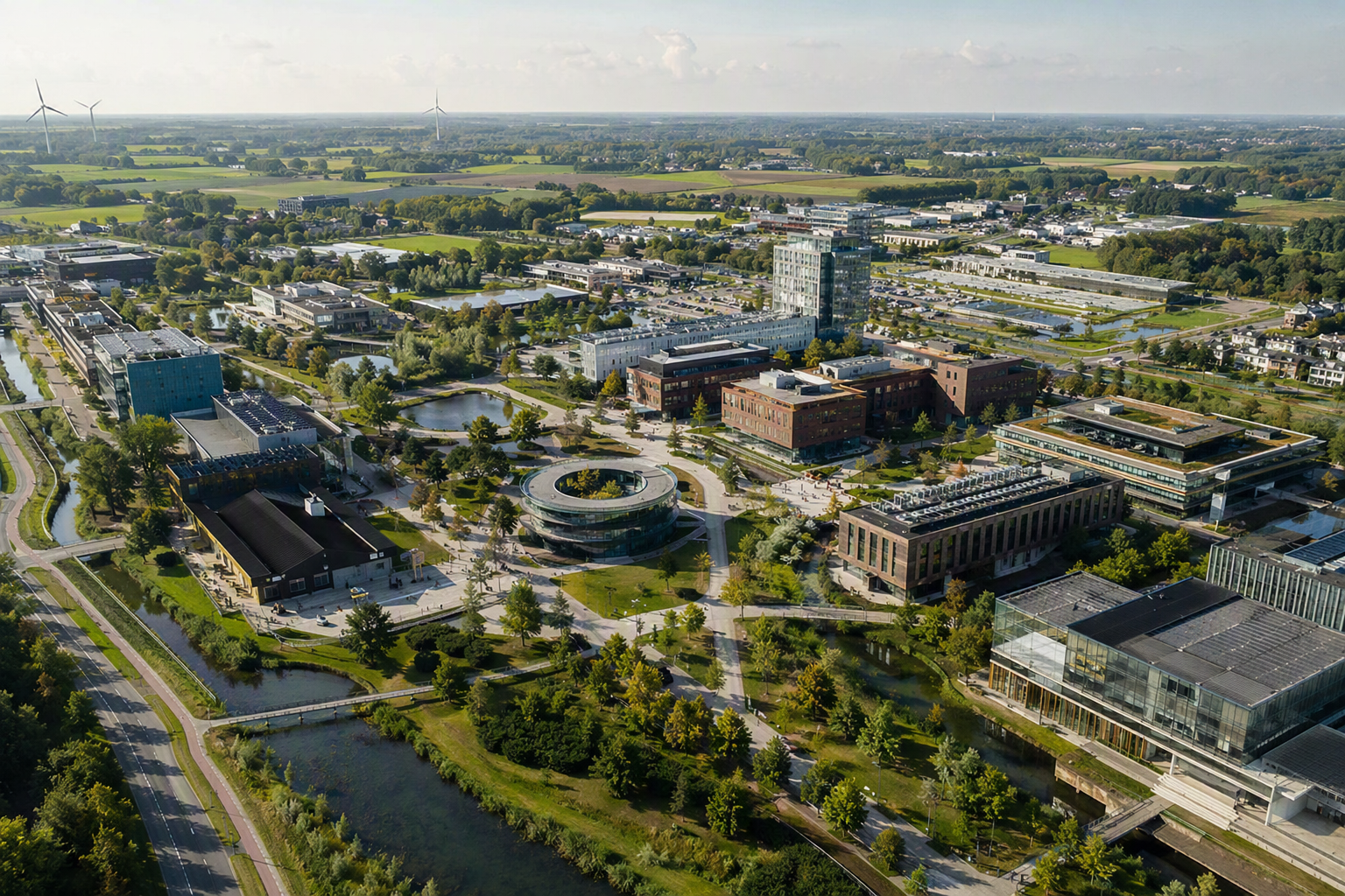 Luchtfoto van een moderne campus met onderwijs-, onderzoeks- en bedrijfsgebouwen in een groene omgeving.