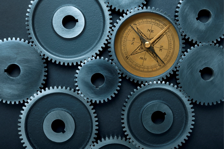 Kompas geïntegreerd in een tandwielmechanisme als symbool voor strategische koersbepaling, samenwerking en organisatieontwikkeling.