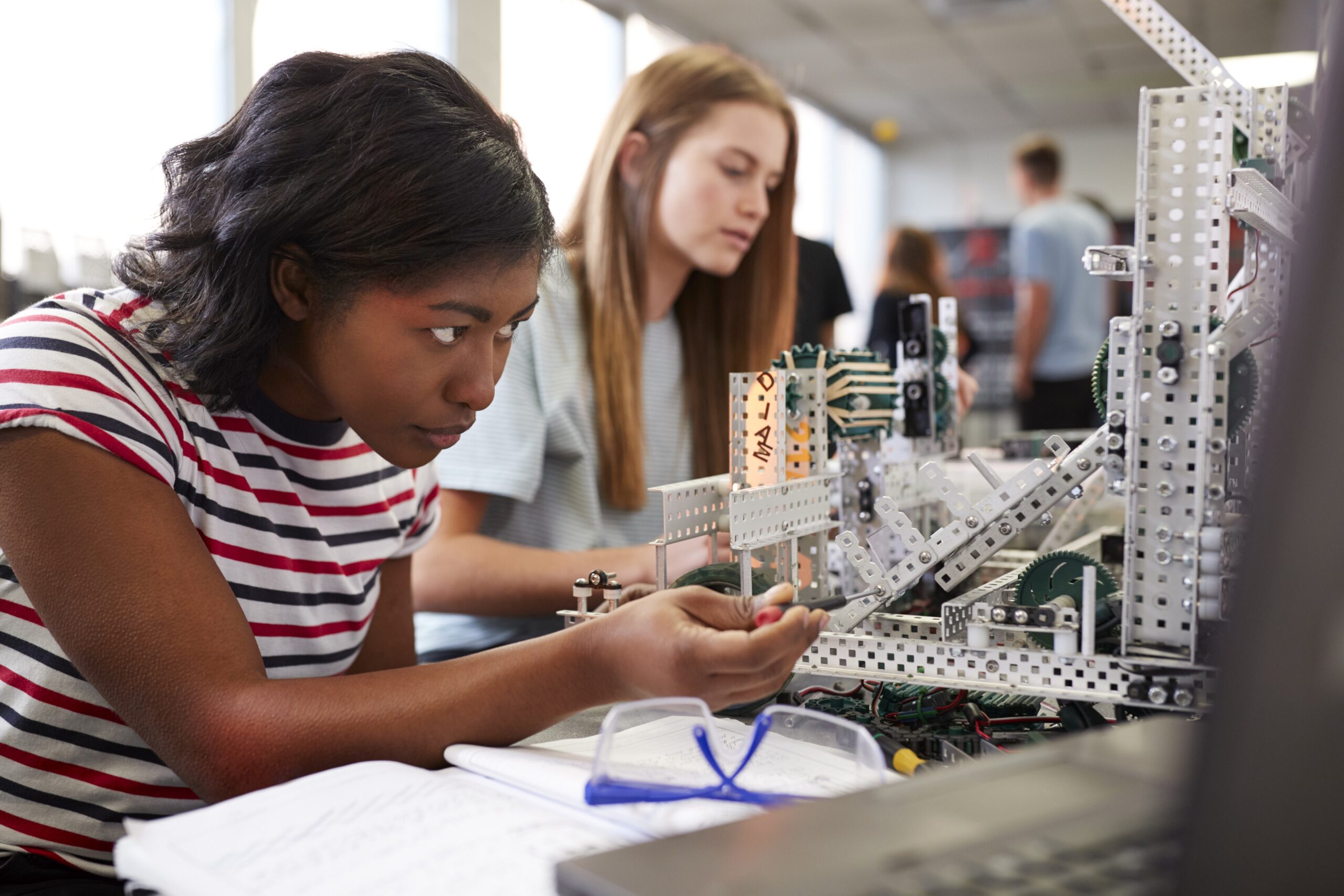 Studenten werken aan een technisch project in een praktijkgerichte leeromgeving met innovatieve technologie.
